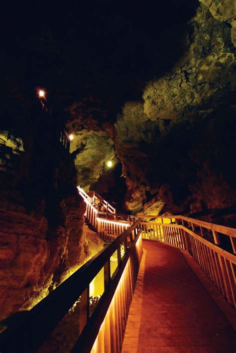 a wooden walkway leading into a cave with lights on