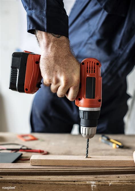 Download premium photo of A carpenter using a drill on a wood 102211 ...