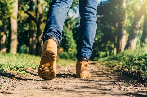 Premium Photo | Feet of an adult wearing boots to travel walking in a ...