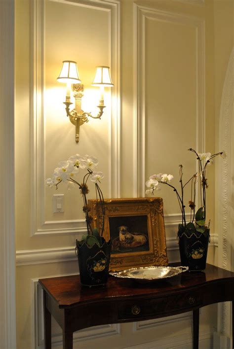 beautiful setting featuring classic wall panels and cast brass sconce ...