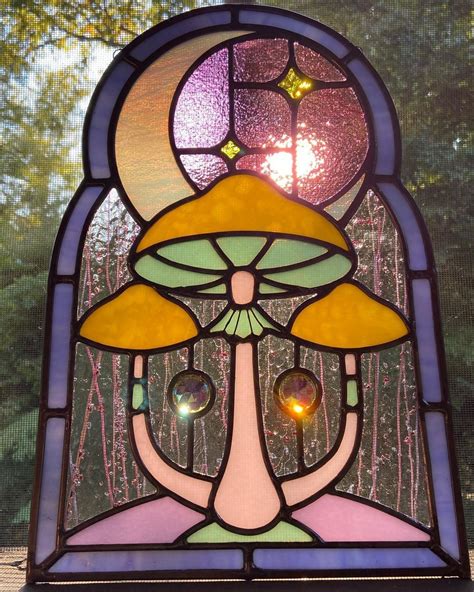a close up of a stained glass window with a mushroom on it's face