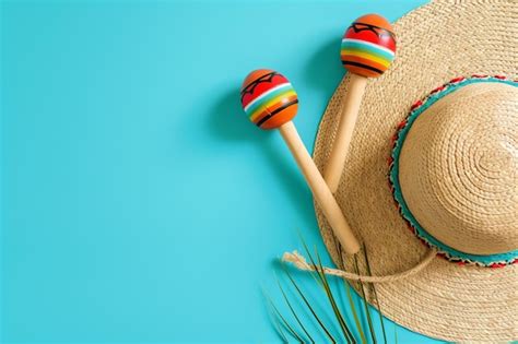 Premium Photo | Mexican straw hat and maracas blue studio background top