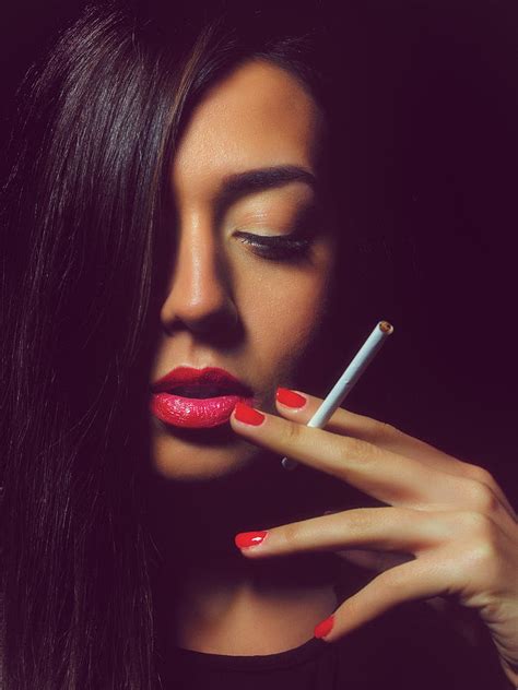 Portrait of the beautiful elegant girl smoking cigarette on black ...