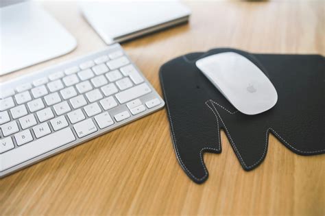 White Apple mouse and keyboard on the black Elephant Pad · Free Stock Photo