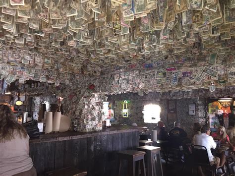 people sitting at tables in a restaurant covered with money bills ...