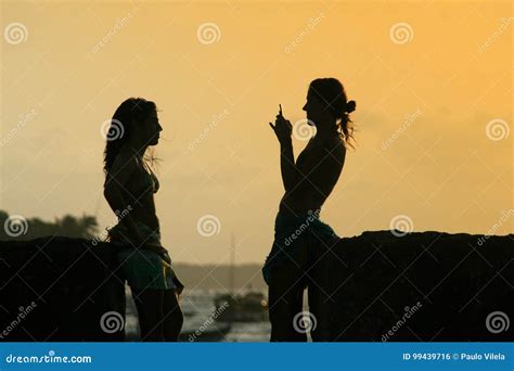 Silhouettes Of Young Group Of People Sitting During Sunset And T ...