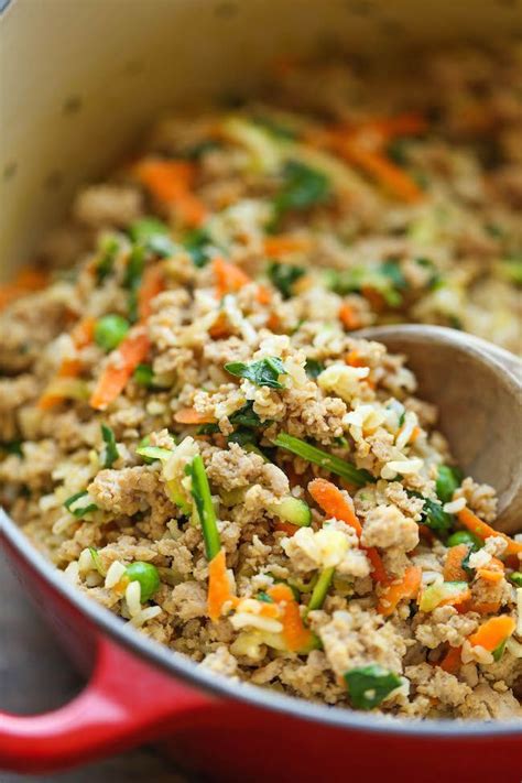 a red pot filled with rice and vegetables