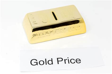 Gold bars and paper with the words GOLD PRICE in front of white ...