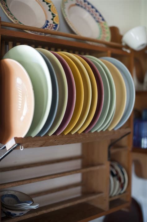 Colorful ceramic plates in a wooden plate rack - Free Stock Image