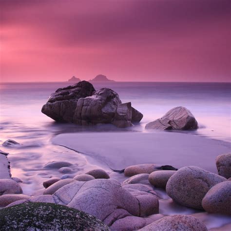 Download Pink Beach Sunset With Rocks Wallpaper | Wallpapers.com