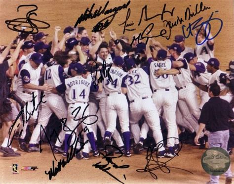 a group of baseball players standing next to each other on a field with their hands in the air