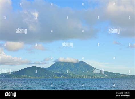 Day view of the Nevis Peak volcano across the water from St Kitts Stock Photo - Alamy