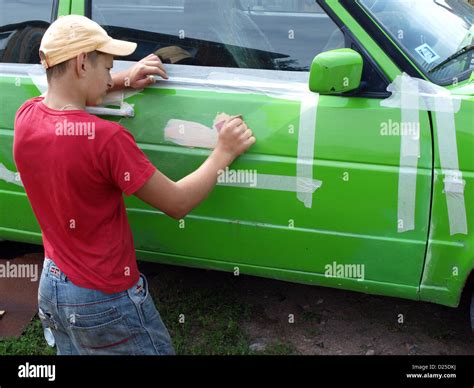 Young boy repair green color car body sanding putty Stock Photo - Alamy