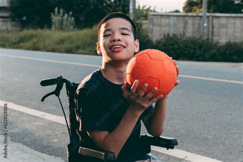 Asian special child on wheelchair is playing basket ball to strengthen ...