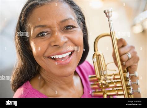 Mixed race woman holding trumpet Stock Photo - Alamy