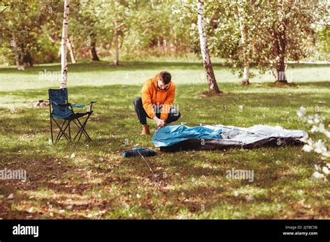 man setting up tent outdoors Stock Photo - Alamy