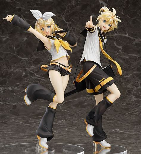 two anime figurines are posed in front of a marble background, one is pointing at the camera