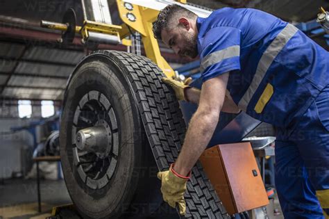 Tire repairer applying tire tread stock photo