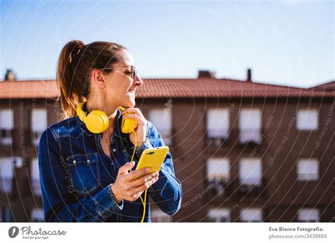 Young teenager standing and listening music outdoors - a Royalty Free Stock Photo from Photocase