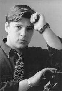 black and white photograph of a young man with his hands on his head ...