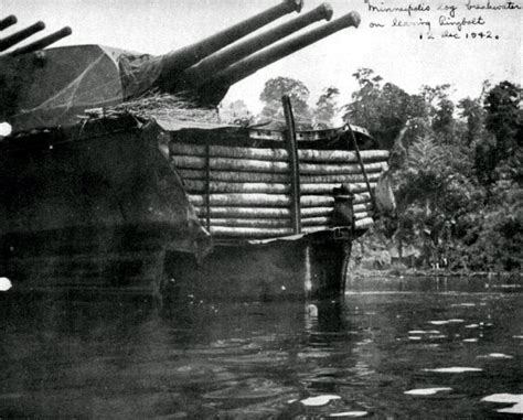 USS Minneapolis (CA 36) with a temporary bow and breakwater constructed from coconut logs ...