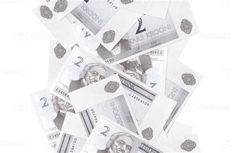 2 Estonian kroon bills flying down isolated on white. Many banknotes falling with white ...