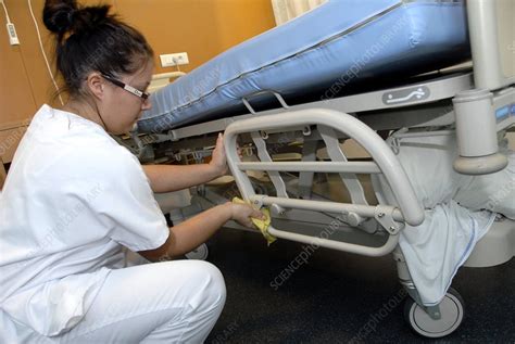 Nurse cleaning hospital bed - Stock Image C001/3108 - Science Photo Library