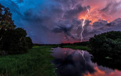 Stormy Reflection: Nature's HD Wallpaper with Lightning and River