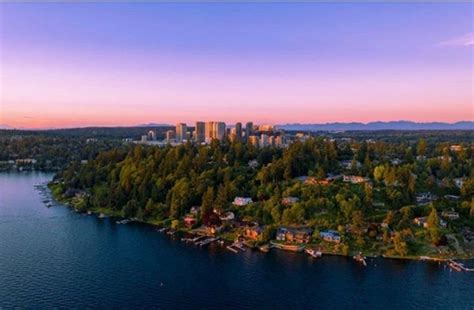 an aerial view of a city and lake at sunset