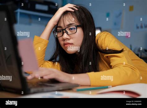 Stressed exhausted woman sitting at office desk and working overtime, she is overloaded with ...