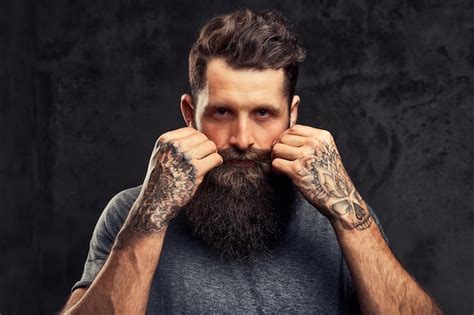 Free Photo | Portrait of a tattooed hipster with full beard and stylish haircut, dressed in a ...