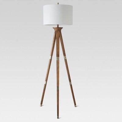 a wooden tripod floor lamp with a white shade