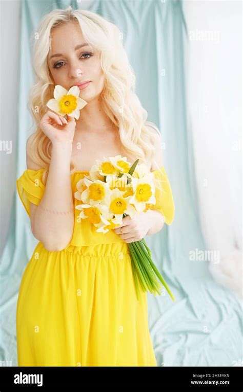 blonde girl in yellow dress posing in spring Stock Photo - Alamy