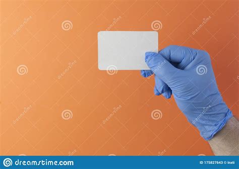 Hand in a Blue Medical Glove Holds a Blank Form of Paper on a Yellow Background. Mock Up ...