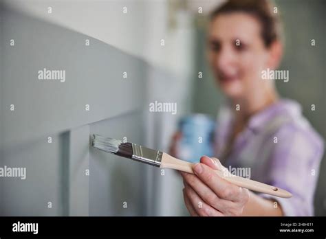 Woman Painting Wall With Panelling In Room Of House With Paint Brush Stock Photo - Alamy