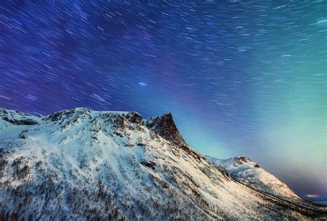 Premium Photo | Mountains and starry night sky senja islands norway stars trails and high peak ...