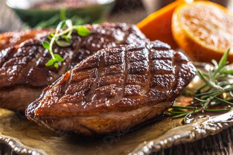 Freshly roasted duck breasts resting on a plate with herbs - stock photo 2366169 | Crushpixel