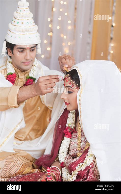 Couple performing Sindoor Daan ceremony in Bengali wedding Stock Photo - Alamy