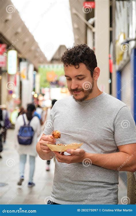 Latin Young Man Eating Takoyaki at Dotonbori Street in Osaka, Japan ...