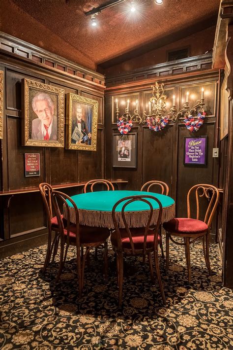 a dining room table with four chairs and pictures on the wall behind it ...