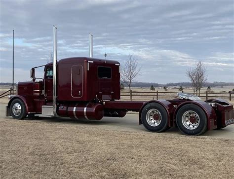 a red semi truck parked on the side of a road