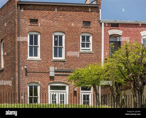 A beautiful view of the exterior design of a brick house with white classic style windows and ...