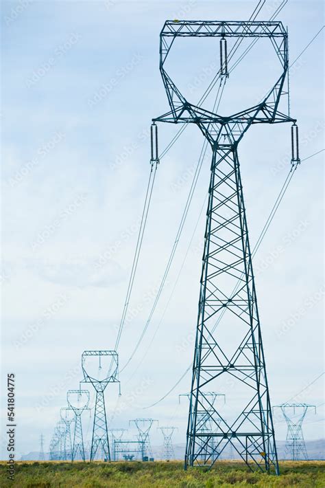 Electrical transmission towers recede into the distance on a flat landscape Stock Photo | Adobe ...