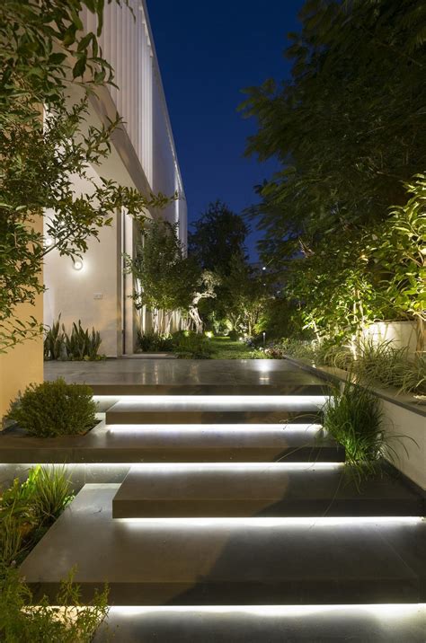 Escalera de entrada iluminada por la noche en la moderna casa LB por Shachar Rozenfeld ...