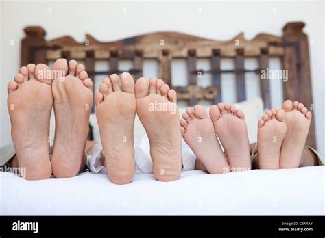 family lying on bed, feet lined up Stock Photo - Alamy