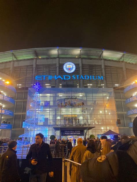 people are standing in front of the stadium entrance at night with ...