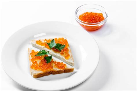 Two triangular sandwiches with salted red caviar on white background - Creative Commons Bilder