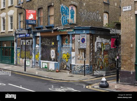 Boarded up building covered in graffiti and Street Art, Paul Street, London, EC2 Stock Photo - Alamy