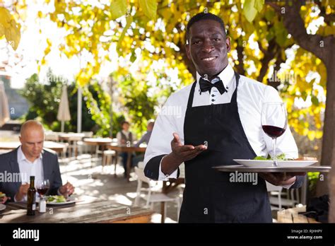 African american waiter who is standing with order at summer cafe Stock ...