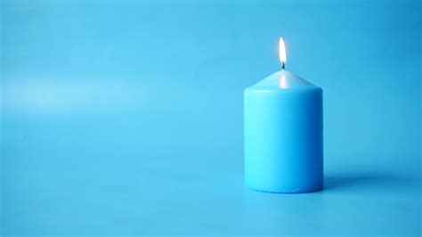 Blue candle lit on blue background 13826653 Stock Video at Vecteezy